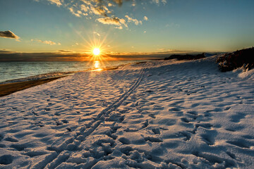 Snow on the beach allows for Cross-country Skiing during sunset on South Beach, Martha's Vineyard