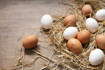 Organic eggs in nest on wooden background.