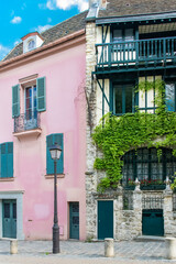 Naklejka premium Paris, France, famous pink house and buildings in Montmartre, in a typical street 