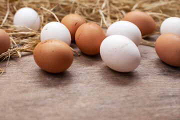 Organic eggs in nest on wooden background.