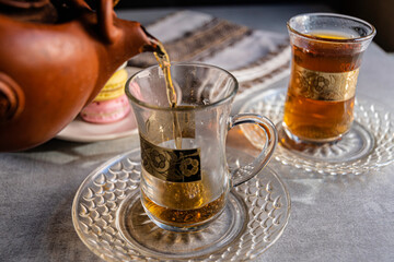 French macaroons and tea in Turkish glasses with gold pattern.