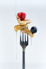 pancake on a fork with strawberries on white background