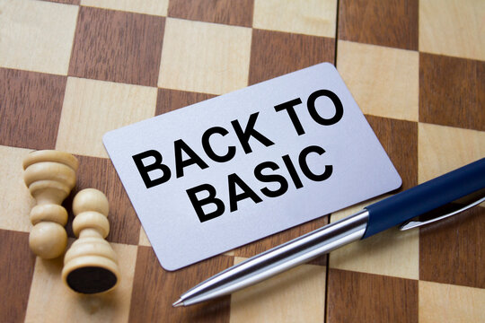 Business card with text Back To Basic on a chess board with pen and eyeglasses
