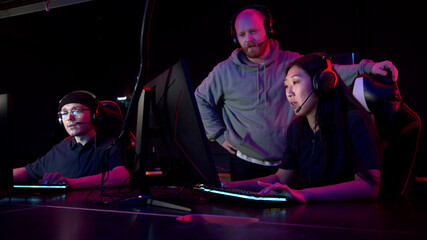 Individual training sessions with an esports coach in a computer club, an asian girl plays strategy © iaginzburg