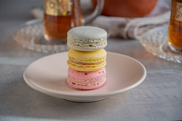 French macaroons and tea in Turkish glasses with gold pattern.