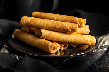 Sweet waffle tubes rolls on plate.