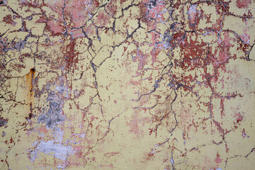 Peeling paint on the wall. Old concrete wall with cracked flaking paint. Weathered rough painted surface with patterns of cracks and peeling. High resolution texture for background and design. Closeup
