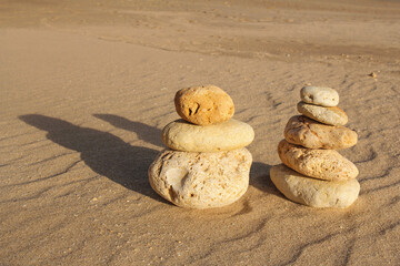 pile of pebbles on a sandy beach, balance, zen concept