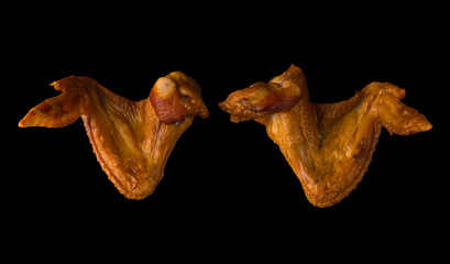 Smoked appetizing chicken legs, chicken lids, on a black background in isolation, poultry meat, chicken smoked meat
