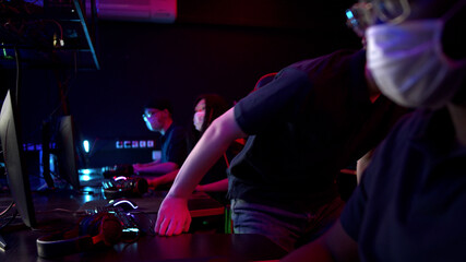 A difficult training day at the cyber team bootcamp is over, the masked gamers take off their headphones, get up from the table and leave