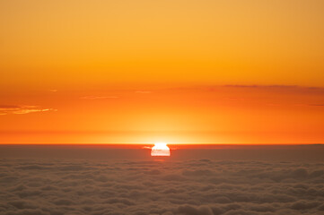 Scenic sunset of sun hiding in clouds sea