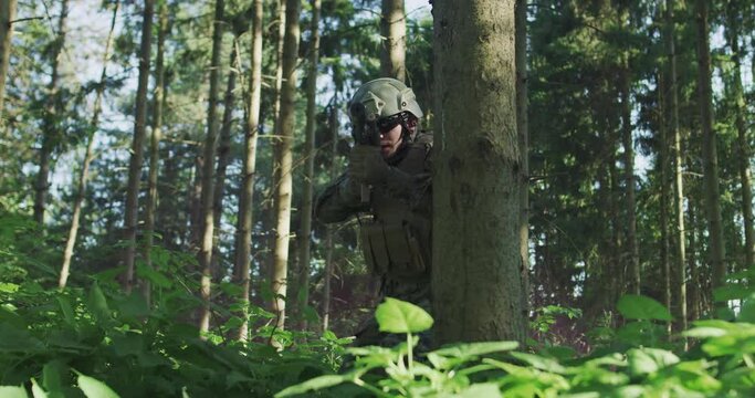 Portrait of soldier in uniform in dense forest ready for military action