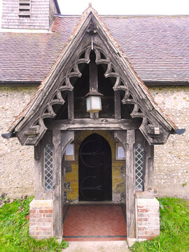 A wooden decorative structure as a vestibule with a roof in front of the entrance to the church