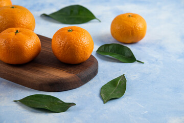 Close up photo of fresh clementine mandarins with leaves