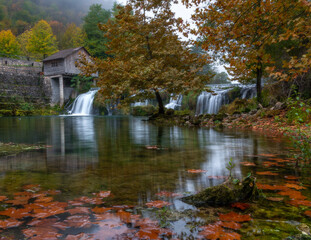 Fototapeta na wymiar autumn by the old mill and waterfalls