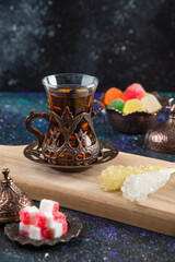 Vertical photo of Hot tea and sweet candies on wooden baord