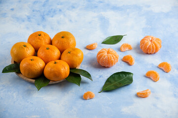 Pile of Clementine mandarins on wooden plate and ground