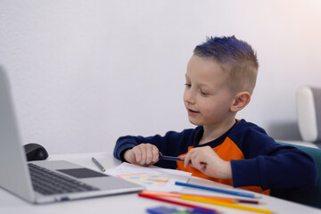 Distance learning and online education. Schoolboy boy studies at home and does school homework. Remote learning during corona pandemic