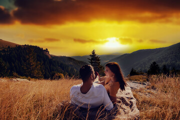 Happy couple hugging on the top of a mountain.
