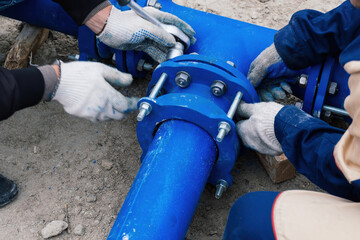 Workers installing water supply pipeline system, close up