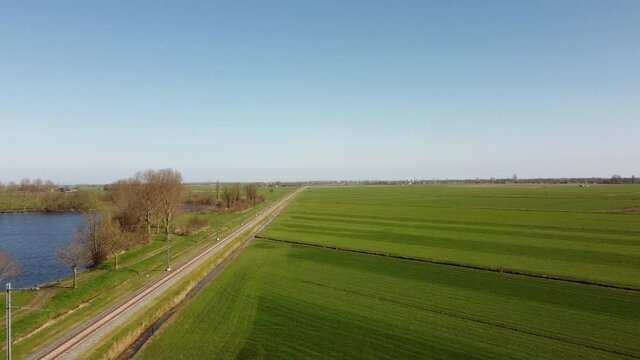 Train of Keolis and Overijssel province driving on the Kamperlijntje in a rural landscape. The commuter train connects the city of Kampen to Zwolle in Overijssel, The Netherlands. High angle drone vie