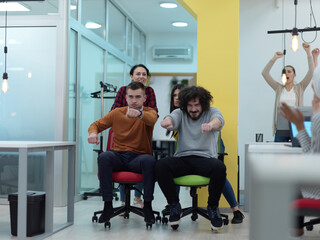 Multiethnic startup group at office chair race