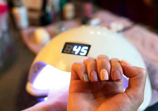 woman in beauty salon having a manicure and gelish. with pink nails