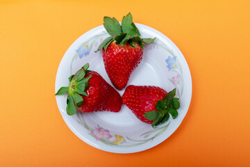 fresh strawberries with leaves on color background
