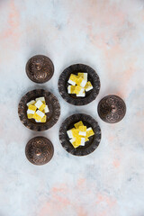 Vertical photo of Yellow candies on crockery over white background