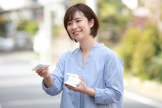 ティッシュ配りする女性 - a woman holding a cup and a cell