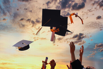 International students in mortar boards and bachelor gowns with diplomas. - 424612670