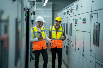 Engineer and technical worker working on the checking status switchgear electrical energy...