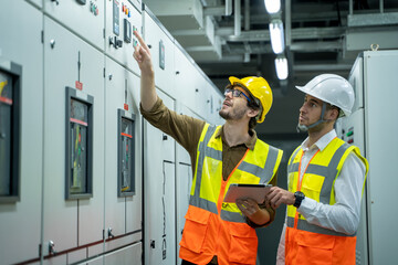 Engineer and technical worker working on the checking status switchgear electrical energy...