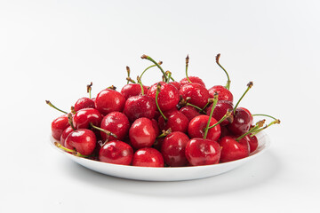 Obraz na płótnie Canvas Cherry berries fruit in a plate on white background.Close-up. 