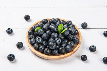 Fresh blueberry with drops of water on wood background