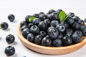 Fresh blueberry with drops of water on wood background