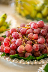 Plate of red grapes in a cluster on a table being catered for a wedding ceremony