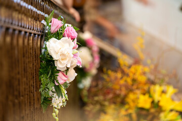 Bouquet of pink and white roses place on a railing for a wedding ceremony