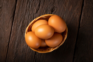 Basket with brown chicken eggs goes up the table.