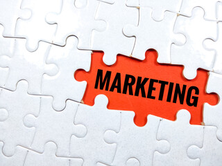 Fototapeta premium Selective focus.Word MARKETING with jigsaw puzzle on red background.Business concept.