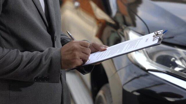 A young business man signs a luxury car leasing contract And sign a car insurance purchase contract on the documents according to the agreement