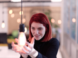 businesswoman holding hands around light bulb