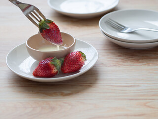 イチゴに練乳をつけて食べるところ
