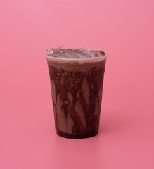 Plastic cup of iced cocoa on pink background