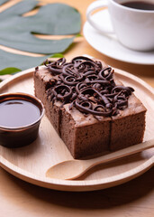 Sweet and tasty chocolate cake with chocolate sauce on table