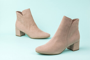 A pair of suede women's half-boots on a light background.