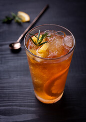 Orange iced tea in a glass on a rustic wooden background.