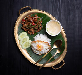 Rice topped with stir-fried pork and basil,fired egg on the table