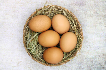 Fresh chicken eggs in a basket with straw
