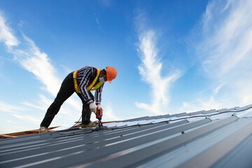 Builders in work clothes install new roofing tools, roofing tools, electric drill and use them on...